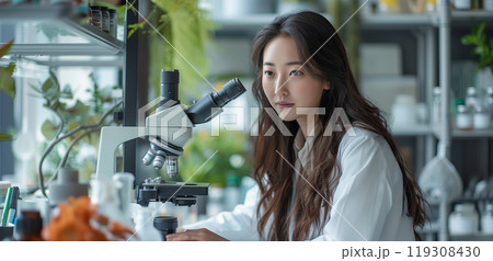 Female Asian Scientist Using Microscope In Research Lab 119308430