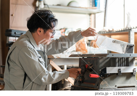 丸鋸・昇降盤を使う作業着姿の中年男性 丸鋸・昇降盤を使う作業着姿の中年男性 119309783