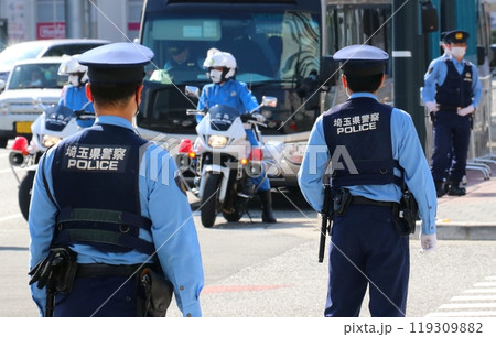 大規模な警備現場での警察官（男性2名、上半身後ろ姿、背景ぼけ） 119309882