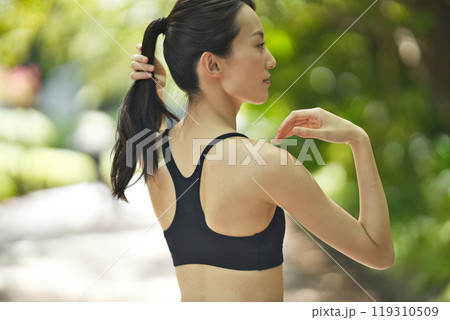 緑の中をランニングするスポーツウエア 119310509