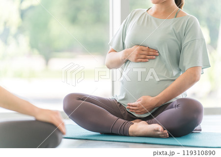 ヨガ教室でマタニティヨガを行う若い妊婦の女性 ヨガ教室でマタニティヨガを行う若い妊婦の女性 119310890