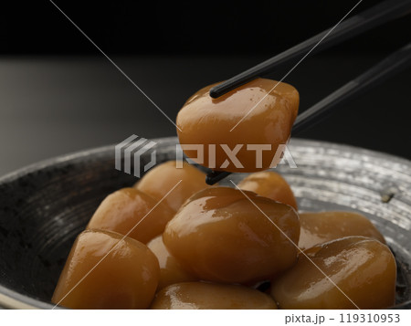 玉こんにゃくの煮物 玉蒟蒻の煮込み料理を箸で持ち上げる 119310953