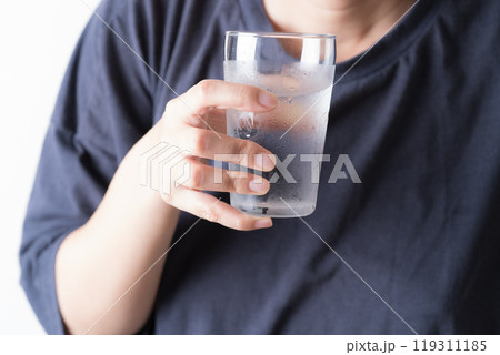 水の入ったグラスを持つ中年女性の手元 水の入ったグラスを持つ中年女性の手元 119311185