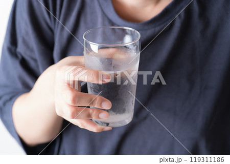 水の入ったグラスを持つ中年女性の手元 水の入ったグラスを持つ中年女性の手元 119311186