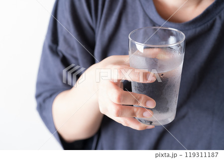 水の入ったグラスを持つ中年女性の手元 119311187