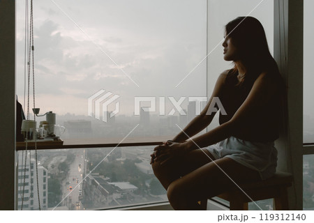 Introvert single woman sitting looking out the view enjoy being alone. Introvert single woman sitting looking out the view enjoy being alone. 119312140