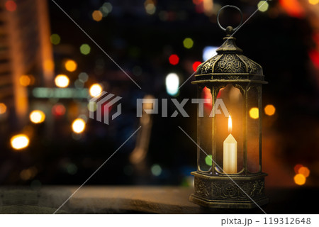 Ornamental arabic lantern with burning candle on the table. Muslim holiday decoration 119312648