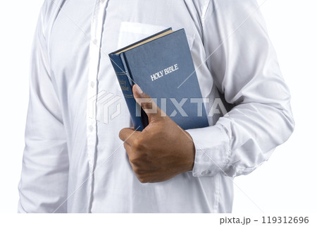 Christian man holding a holy bible in his hand. Symbol of faith in God, Christianity Feast Christian man holding a holy bible in his hand. Symbol of faith in God, Christianity Feast 119312696