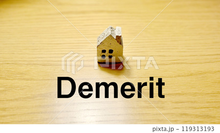 スポットライトの当たったテーブルにポツンと置いた家小物とDemerit文字 119313193
