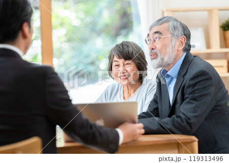 シニア夫婦に説明する営業マン 119313496