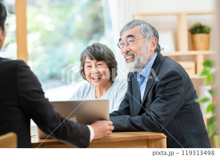 シニア夫婦に説明する営業マン 119313498