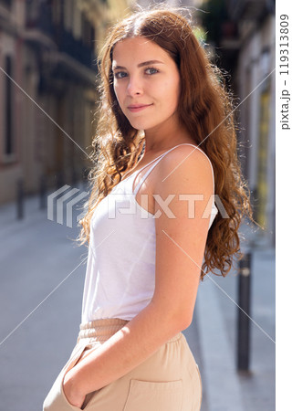 Cheerful attractive female walking on street outdoor Cheerful attractive female walking on street outdoor 119313809
