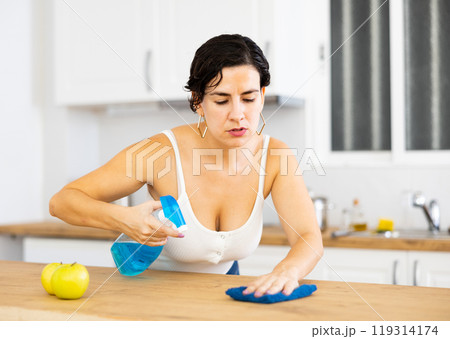 Positive woman keeping home clean and fresh during day, cleaning kitchen table Positive woman keeping home clean and fresh during day, cleaning kitchen table 119314174