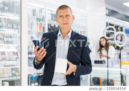 Man buyer choosing phone at the multimedia store 119314314