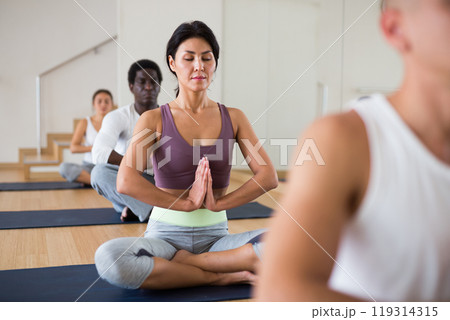 Young woman practicing meditation at yoga class Young woman practicing meditation at yoga class 119314315