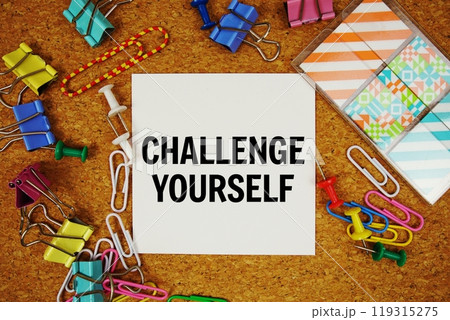 Challenge Yourself text on paper card with stationery on cork board background 119315275