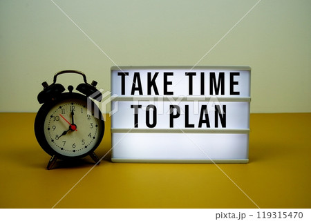 Take Time To Plan text on LED lightbox with alarm clock on yellow background 119315470