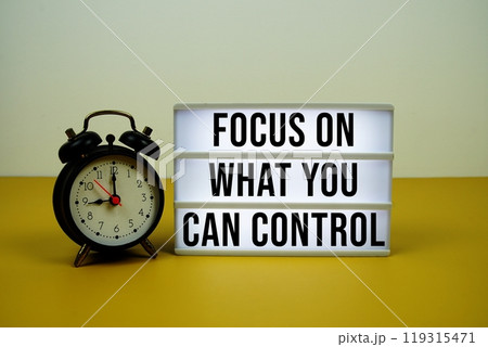 Focus On What You Can Control text on LED lightbox with trolley shopping cart on yellow background 119315471