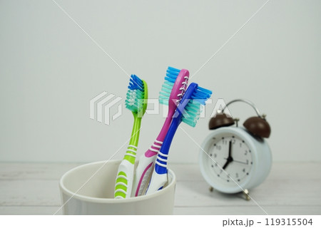 Toothbrush with alarm clock dental hygiene concept on wooden background 119315504