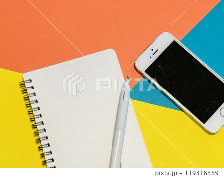 白紙のノートとスマホ（カラフル背景） 119316389