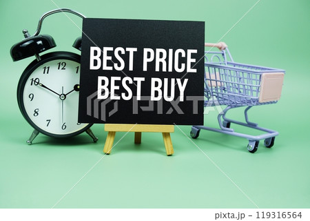 Best Price Best Buy text message on paper card with alarm clcok and trolley shopping cart on green background 119316564