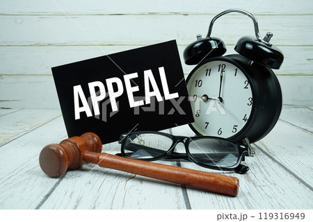 Appeal text on paper card with alarm clock and wooden judge gavel on wooden background Appeal text on paper card with alarm clock and wooden judge gavel on wooden background 119316949