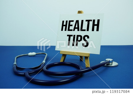Health Tips text message on paper card with stethoscope on blue background 119317084