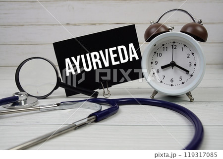 Ayurveda text message on paper card with stethoscope and alarm clock on wooden background Ayurveda text message on paper card with stethoscope and alarm clock on wooden background 119317085