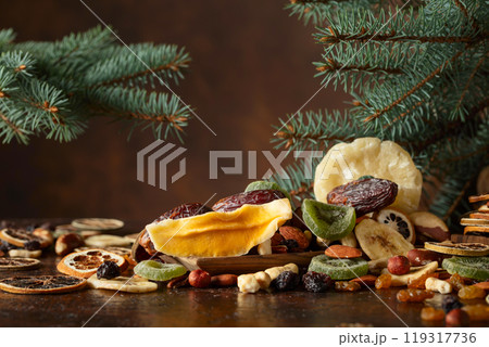 Dried tropical fruits with various nuts and raisins on a old brown table. 119317736