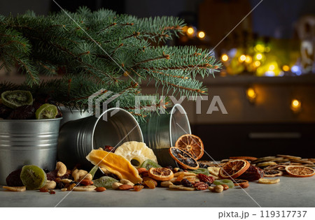 Sweet tropical fruits and Christmas tree on a kitchen table. Sweet tropical fruits and Christmas tree on a kitchen table. 119317737