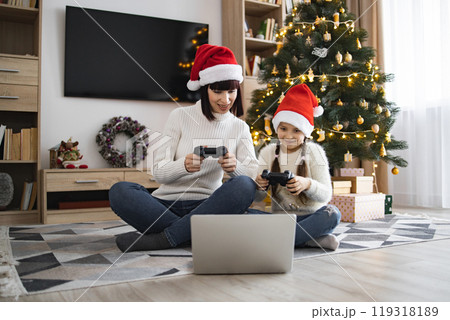 Mother and daughter play video games at Christmas time Mother and daughter play video games at Christmas time 119318189