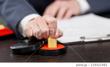 契約書に印鑑を押すビジネスマンの手元 119321481