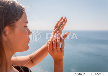 A woman with long hair is standing on a beach A woman with long hair is standing on a beach 119322485