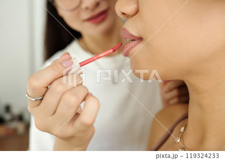Artist Applying Lipstick On Lips Of Model 119324233