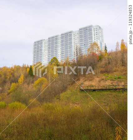 multi-story residential building on top of a hill with autumn trees 119324853