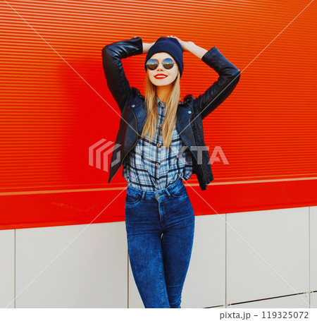 Fashion portrait beautiful blonde smiling woman model in rock black style on red background Fashion portrait beautiful blonde smiling woman model in rock black style on red background 119325072