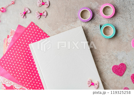 Creative supplies for scrapbooking and crafting on a textured surface with decorative tape and heart confetti Creative supplies for scrapbooking and crafting on a textured surface with decorative tape and heart confetti 119325258