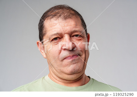Middle-aged man with a thoughtful expression against a plain background Middle-aged man with a thoughtful expression against a plain background 119325290