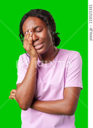 Woman expressing frustration while standing against a bright green background 119325381