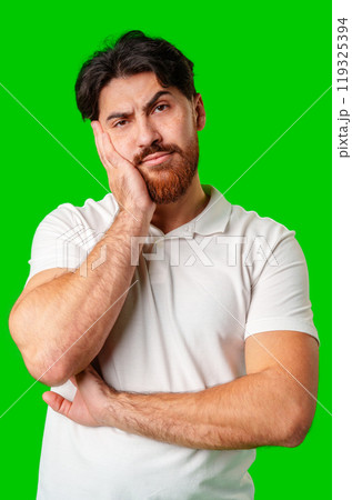 A man with a serious expression stands against a vibrant green background 119325394
