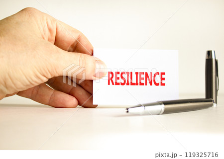 Resilience symbol. Concept word Resilience on beautiful white card. Beautiful wooden background. Businessman hand. Beautiful black pen. Business resilience concept. Copy space. Resilience symbol. Concept word Resilience on beautiful white card. Beautiful wooden background. Businessman hand. Beautiful black pen. Business resilience concept. Copy space. 119325716