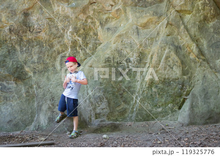 Young boy climbing on a rock, vacation concept. 119325776