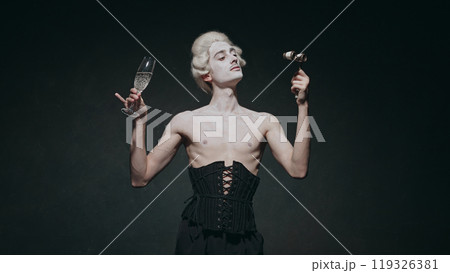 Young man with make-up holds champagne glass, exuding aristocratic vibes with touch of modern surrealism against vintage background. 119326381