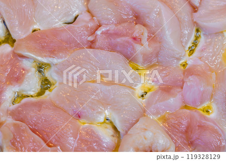 closeup full-frame background of raw chicken breast meat just starting to roast closeup full-frame background of raw chicken breast meat just starting to roast 119328129
