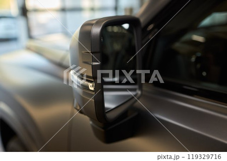 An elegant closeup shot of a sleek car side mirror showcasing its design and details An elegant closeup shot of a sleek car side mirror showcasing its design and details 119329716