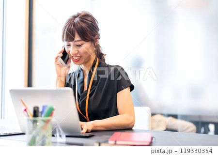 スマホを片手にマルチタスクをこなすビジネスパーソン スマホを片手にマルチタスクをこなすビジネスパーソン 119330354