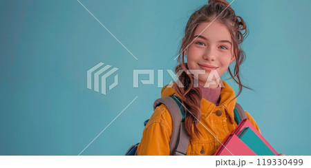 Happy student with a backpack holding books in front of a colorful background Happy student with a backpack holding books in front of a colorful background 119330499