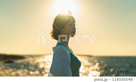 夕暮れの海辺にたたずむ女性 夕暮れの海辺にたたずむ女性 119330549