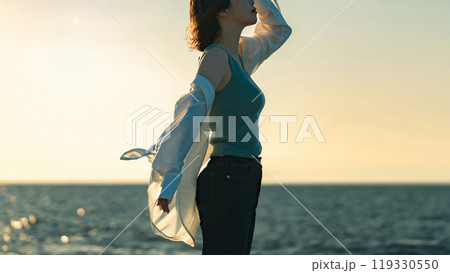 夕暮れの海辺にたたずむ女性 夕暮れの海辺にたたずむ女性 119330550