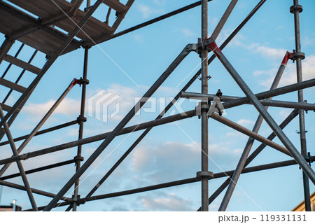 A minimalist urban scene showcasing a construction site with a towering crane. Highlights the intersection of infrastructure, development, and modern architecture under a clear sky. A minimalist urban scene showcasing a construction site with a towering crane. Highlights the intersection of infrastructure, development, and modern architecture under a clear sky. 119331131